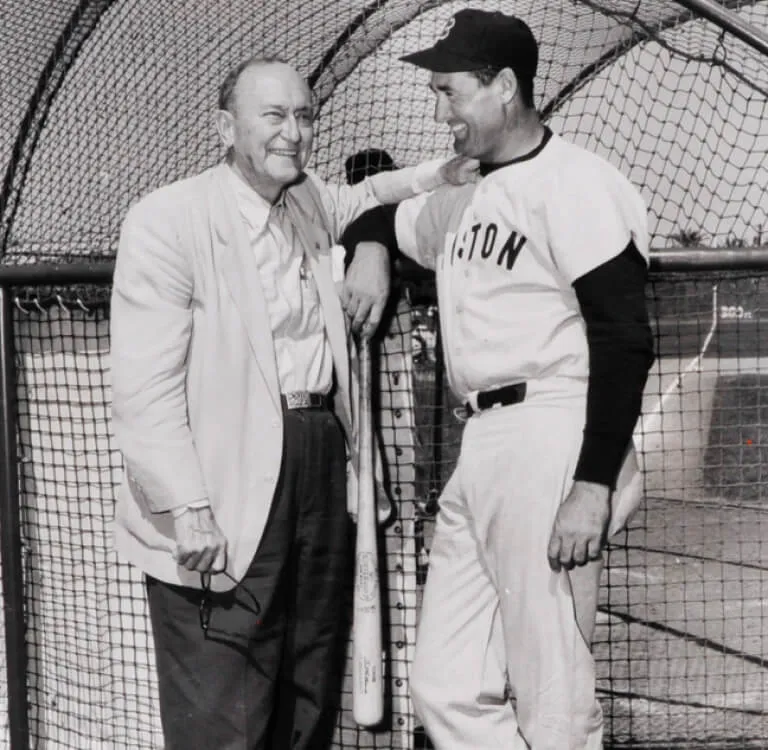 A baseball player and a man in a suit standing together and smiling