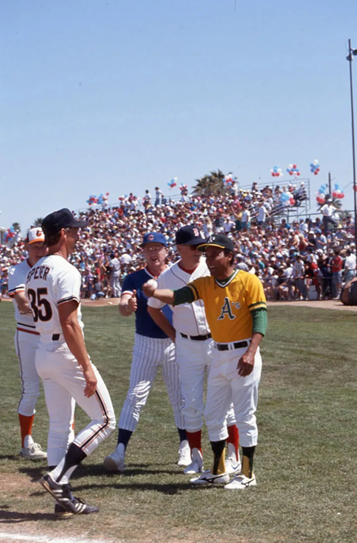 A group of baseball players smiling at each other on the field