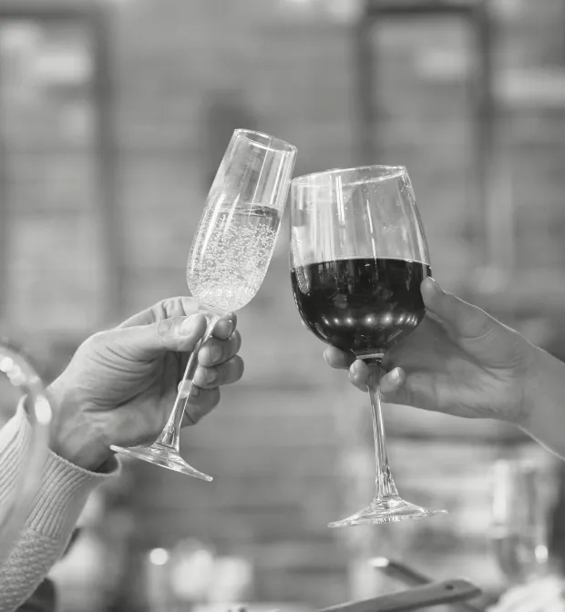 Two people clinking wine glasses together