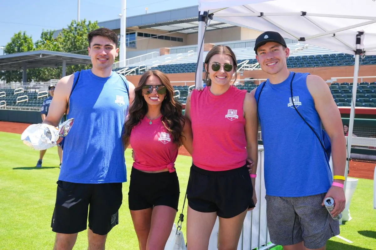 a group of four people standing together and smiling
